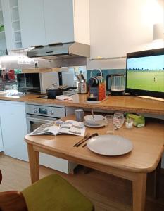 uma cozinha com uma mesa de madeira com pratos e copos de vinho em Appartement, place Morny. em Deauville
