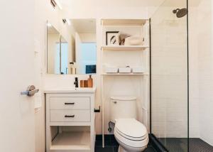 a white bathroom with a toilet and a shower at Luxury Apt in West Oakland - Near Downtown in Oakland