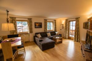 Alpinchalet Apartment Enzian في أورتيساي: غرفة معيشة مع أريكة وطاولة