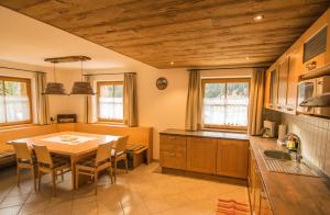 een keuken met een tafel en stoelen in een kamer bij Alpinchalet Apartment Enzian in Ortisei