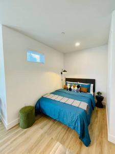 a bedroom with a blue bed in a white room at Luxury Furnished Studio Suite close to Downtown in Oakland