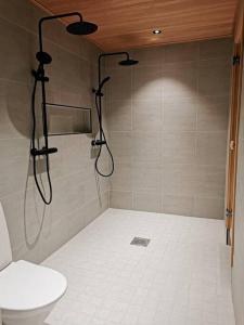 y baño con ducha y aseo. en Private Villa, 127m2, 3 br, sauna, fast wifi en Rovaniemi