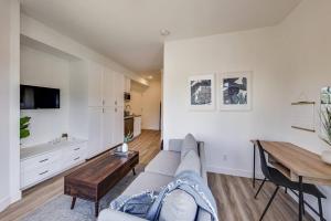 een woonkamer met een bank en een houten tafel bij Luxury Furnished Studio Suite in Lake Merritt in Oakland