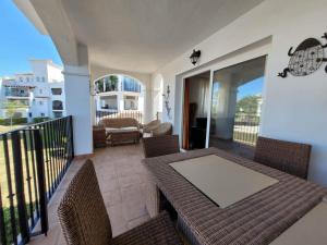 a patio with a table and chairs on a balcony at Belle vue sur la piscine in Sucina