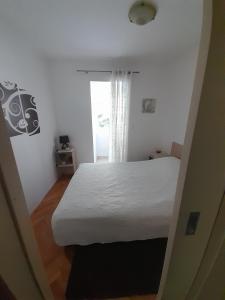 1 dormitorio con cama blanca y ventana en Jasna Herceg Novi, en Herceg-Novi