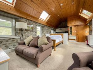 a living room with a couch and a bedroom at Glacour Studio Cottage in Bridgend