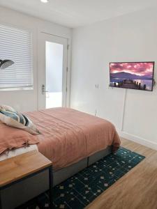 ein Schlafzimmer mit einem Bett und einem TV an der Wand in der Unterkunft Studio Suite Close to Downtown in Oakland