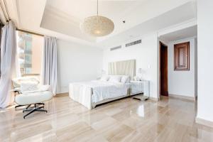 a white bedroom with a bed and a chair at Habitación Privada con vista al mar Ámbar, Malecon Santo Domingo in Santo Domingo +19 photos