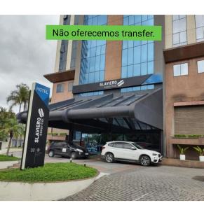 une voiture garée dans un parking en face d'un bâtiment dans l'établissement Flat Guarulhos, à Guarulhos