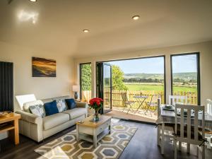 un soggiorno con divano e tavolo di Lodge With A View a Steyning