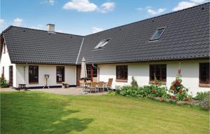 una casa blanca con una mesa y sillas en un patio en 5 Bedroom Stunning Home In Stakroge en Knaplund