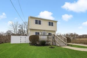 a large house with a porch and a wooden deck at Beautiful Home With Water Views & Close To Ocean in Warwick