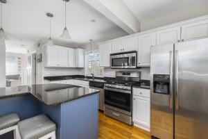 a kitchen with white cabinets and a stainless steel refrigerator at Beautiful Home With Water Views & Close To Ocean in Warwick