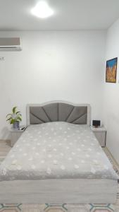 a bed in a white room with a bed frame at parkent plaza apartments in Tashkent