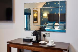 Cette chambre comprend une table avec deux tasses. dans l'établissement Mandolay Hotel Guildford, à Guildford