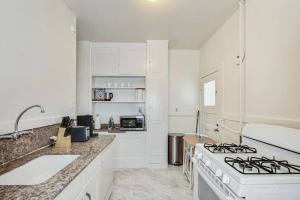 uma cozinha branca com um fogão e um lavatório em Best Location 3BR by UCBerkeley em Berkeley