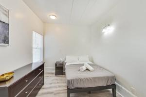 a white bedroom with a bed and a dresser at Best Location 3BR by UCBerkeley in Berkeley