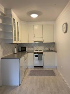 a kitchen with white cabinets and a counter top at Harju Apartment in Jyväskylä