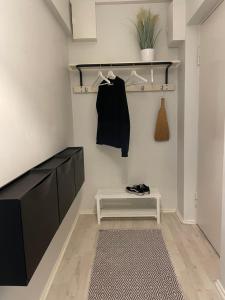 una stanza con armadi neri, un tappeto e una panca di Harju Apartment a Jyväskylä