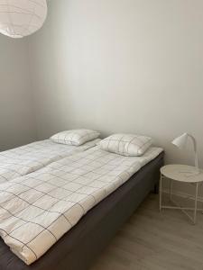 łóżko z 2 poduszkami i stołem w pokoju w obiekcie Harju Apartment w mieście Jyväskylä