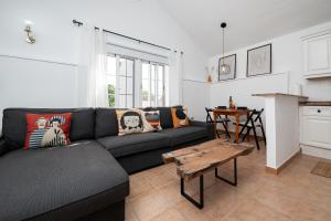 ein Wohnzimmer mit einer schwarzen Couch und einem Tisch in der Unterkunft Casa El Drago 2 in Breña Baja