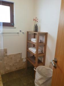 a bathroom with a shower and a shelf with towels at Casinha Laranja in Monchique +39 photos