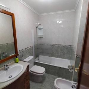 uma casa de banho com uma banheira, um WC e um lavatório. em Apartamento Coqueto 10min centro em Oviedo