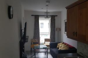 a living room with a blue couch and a window at Ardara Town centre 2 Bed Apt in Donegal