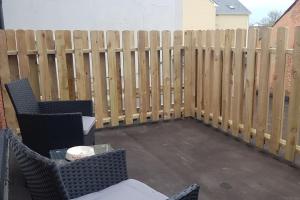 a patio with two chairs and a fence at Ardara Town centre 2 Bed Apt in Donegal