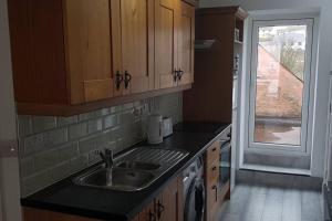 a kitchen with a sink and a counter with a window at Ardara Town centre 2 Bed Apt in Donegal