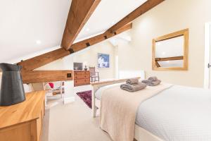 a attic bedroom with two beds and a mirror at Rose Barn in Hawkshead