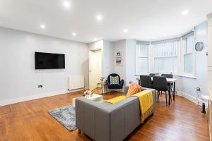 a living room with a couch and a table at Bright St Johns Apartments in London