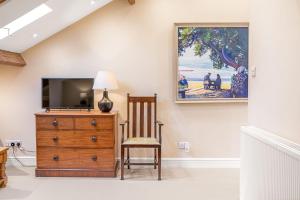 a living room with a tv and a wooden dresser at Rose Barn in Hawkshead