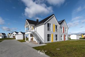 a white house with a black roof at Knuts Koje in Olpenitz