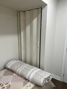 Un dormitorio con una cama con una manta. en one bedroom basement apartment en Milton