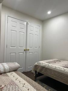1 dormitorio con 2 camas y puerta blanca en one bedroom basement apartment en Milton