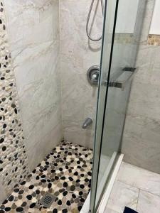 a shower with a glass door and a black at one bedroom basement apartment in Milton