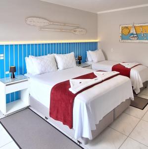 two beds in a room with blue and white at NAVEGA PRAIA HOTEL in Navegantes