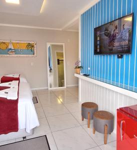 ナヴェガンテスにあるNAVEGA PRAIA HOTELのベッドルーム1室(ベッド1台、壁掛けテレビ付)