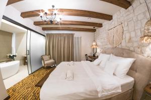 a bedroom with a large white bed and a bathroom at Dwór Bogucin Hotel&Restauracja in Bogucin