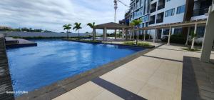 ein großer blauer Swimmingpool neben einem Gebäude in der Unterkunft Mactan Newtown Condo by EJB in Punta Engaño