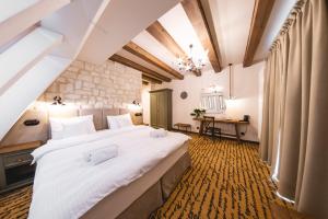 1 dormitorio con 1 cama blanca grande en una habitación en Dwór Bogucin Hotel&Restauracja, en Bogucin