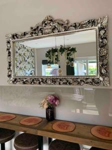 a mirror on a wall above a table with flowers at Jorvik Villa in York