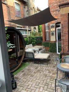 a patio with a table and chairs and an umbrella at Jorvik Villa in York