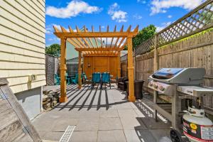 a patio with a wooden pergola and a grill at Beautiful Cottage In Downtown Bristol in Bristol