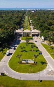 une vue aérienne sur un parc avec des palmiers et une route dans l'établissement Casa com Piscina e Churrasqueira na Riviera em Bertioga, à Riviera de São Lourenço