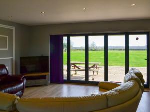 a living room with a couch and a television and a table at Aimmees Lodge - Ukc2203 in Doddington