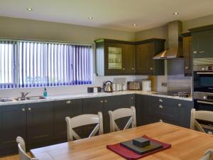 a kitchen with a wooden table and a kitchen with a tableablish at Aimmees Lodge - Ukc2203 in Doddington