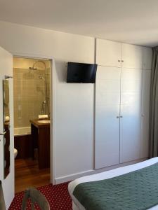 a hotel room with a bed and a bathroom at Hôtel Le Martray in Ars-en-Ré