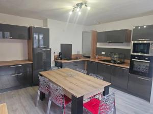 uma cozinha com uma mesa de madeira e algumas cadeiras em L'Estran em Dieppe